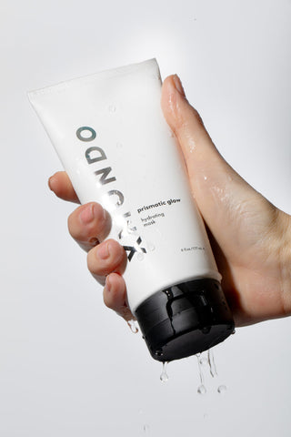 Hand holding Prismatic Glow Hydrating Mask by XMONDO Hair